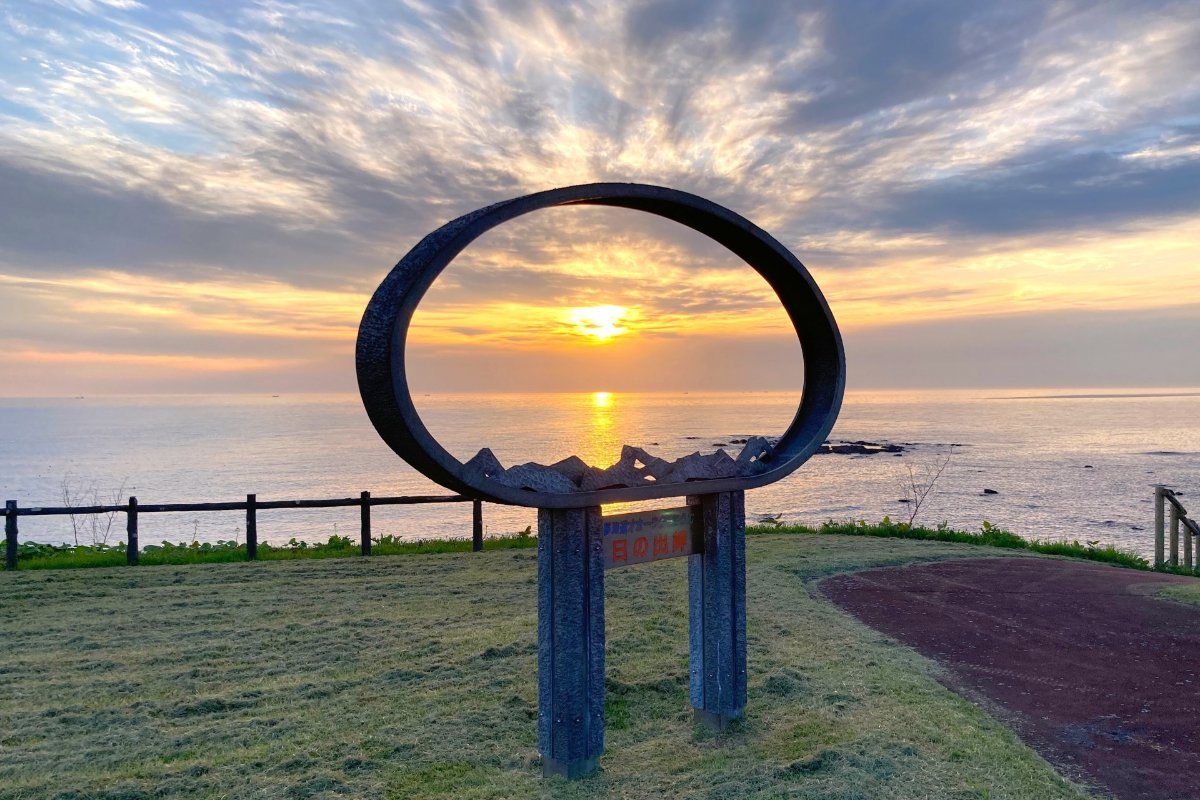 日の出岬のモニュメントとオホーツク海から昇る朝日