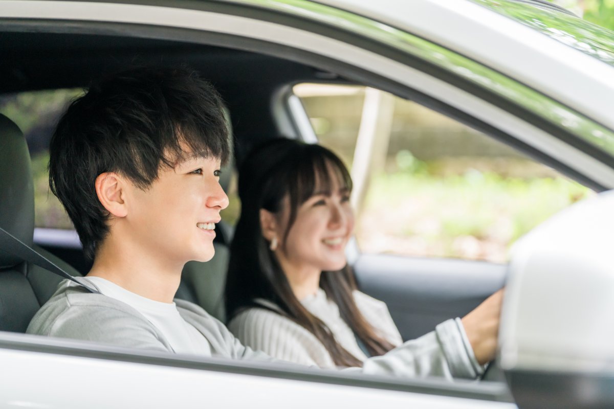 ドライブ中に車内で会話を楽しむカップルのイメージ