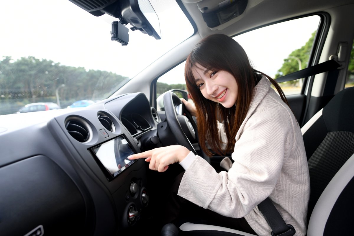 車内でカーナビを操作して次の目的地を決める女性のイメージ